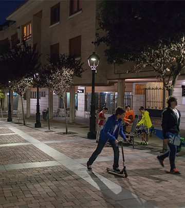 Philips aydınlatma ile geceleyin aydınlatılan Palencia sokaklarında yürüyen insanlar
