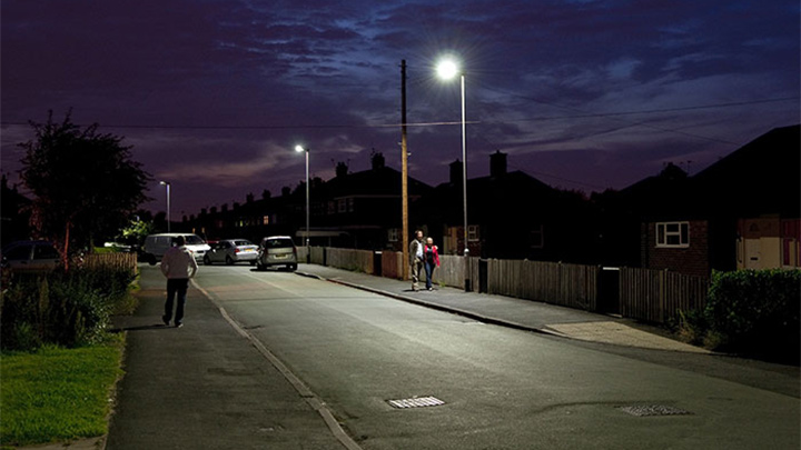 İnsanlar Philips ile aydınlatılmış bir sokakta yürüyor
