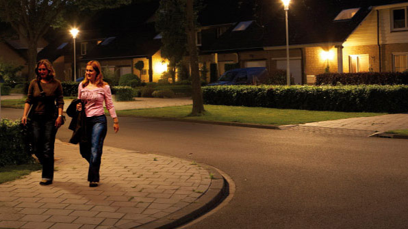 İki kadın Philips beyaz led ışık ile aydınlatılan bir sokakta yürüyor