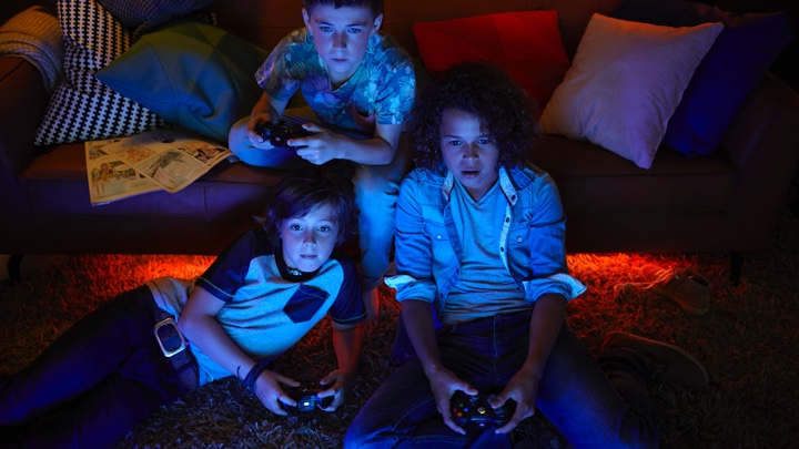 Ortam aydınlatması ile video oyunu oynayan 3 erkek çocuk