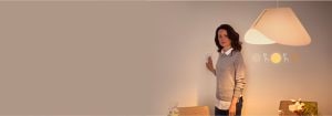 "Kadın akıllı dimmer anahtarını ayarlıyor, minimalist dekorlu çağdaş yaşam alanında sıcak LED aydınlatma ambiyansını kontrol ediyor"