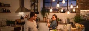 "LED sarkıt lambaları ile aydınlatılmış vintage tarzda modern mutfak, iki kadının akşam yemeğinin tadını çıkarmasını sağlar ve sıcak, davetkar bir atmosfer yaratır."