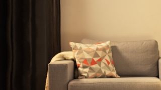 Modern LED masa lambası ile rahat oturma odası, gri sevgili koltuğunu aydınlatan ve evde rahatlamak için sıcak bir ortam yaratan.